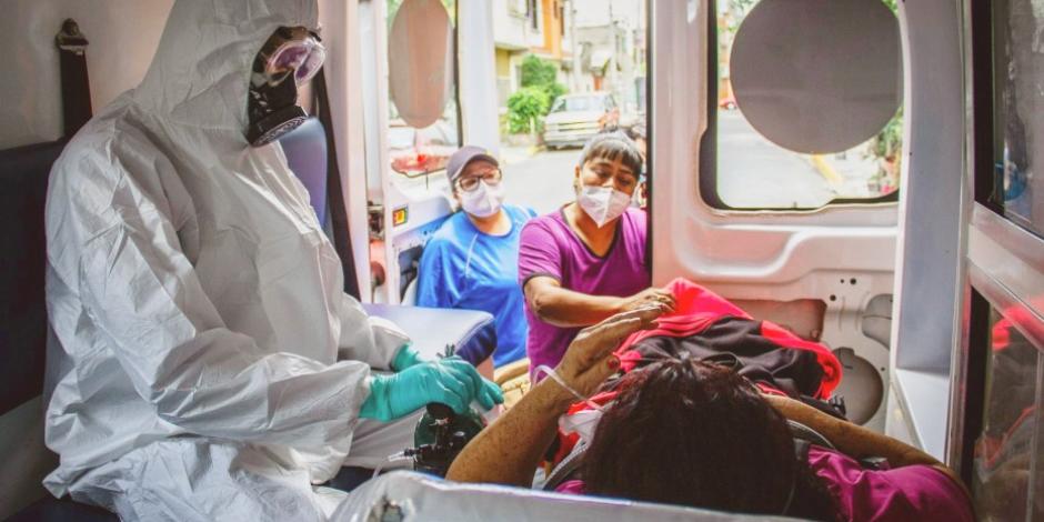 Un paramédico canaliza oxigeno a una señora que tuvo que ser trasladada a un hospital al presentar dificultad para respirar. Al subir a la ambulancia sus hijas le pidieron que fuera fuerte.