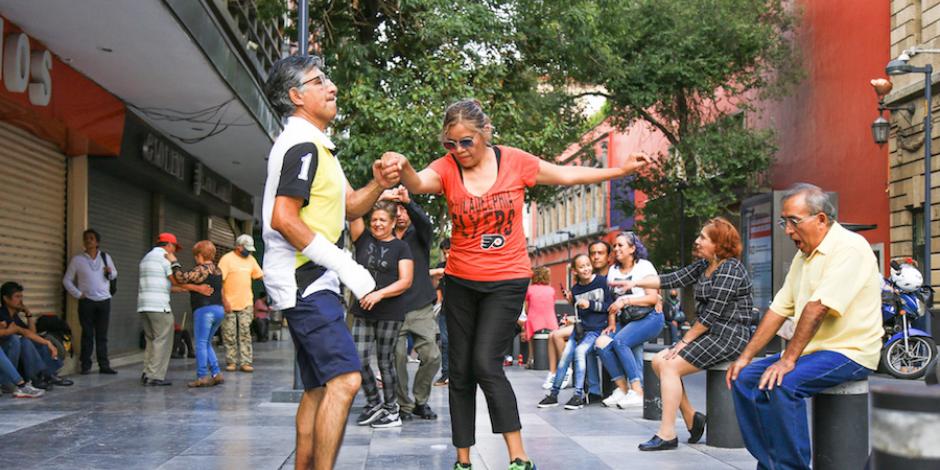Capitalinos bailan al ritmo de un grupo que toca en la calle 16 de Septiembre, en el primer cuadro de la ciudad, ayer.
