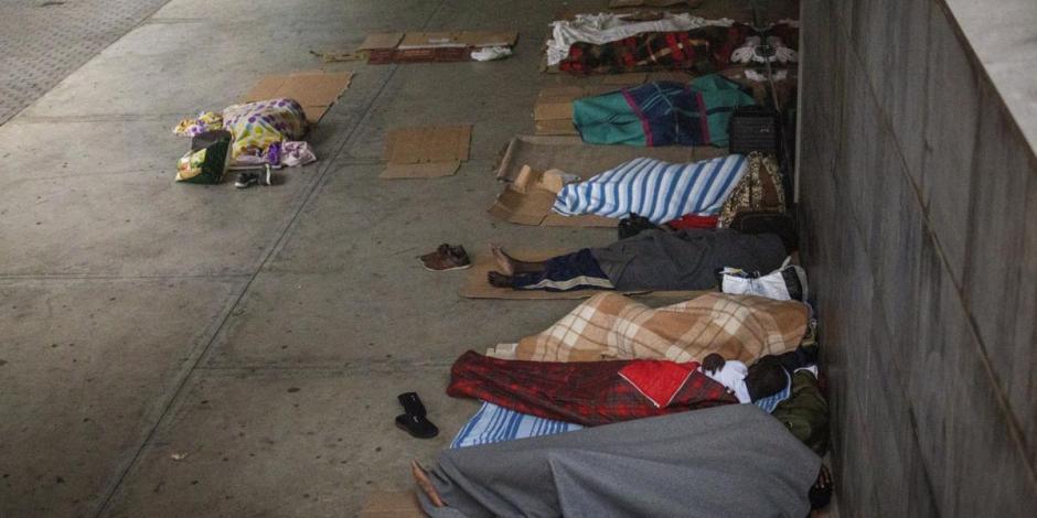 Migrantes que buscan trabajo como jornaleros agrícolas duermen en el piso de una plaza en Lleida, España, el jueves 2 de julio de 2020.