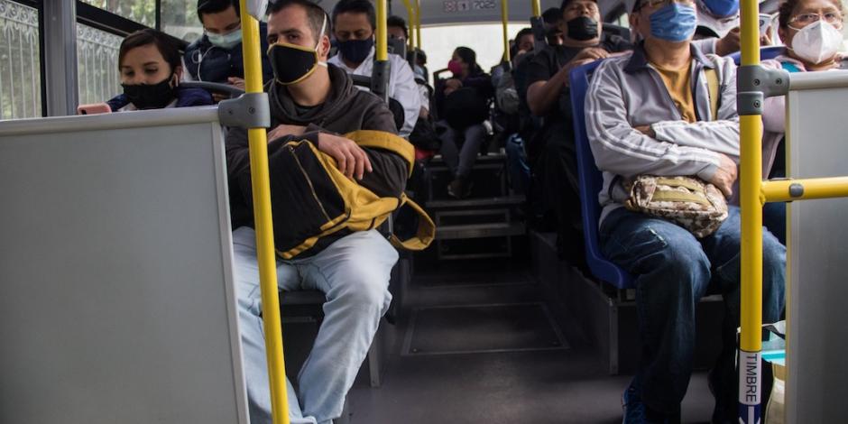 Habitantes de la capital portan cubrebocas mientras viajan en un autobús de transporte público con todos los asientos ocupados, ayer.