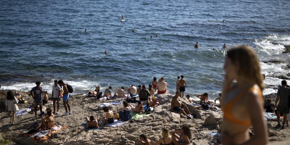 Gente disfruta del sol y la playa Malmousque en Marsella, al sur de Francia
