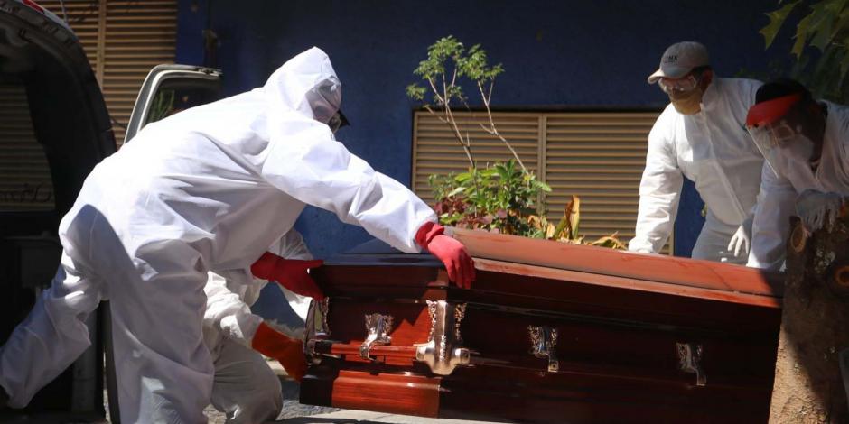 Personal de servicios funerarios traslada el cuerpo de un paciente que falleció por COVID-19.