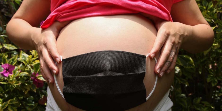 Mujer embarazada se coloca cubrebocas en el vientre como signo de protección para el bebé.
