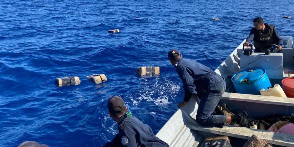 Elementos de la Marina recogen del mar los paquetes que abandonaron los delincuentes.