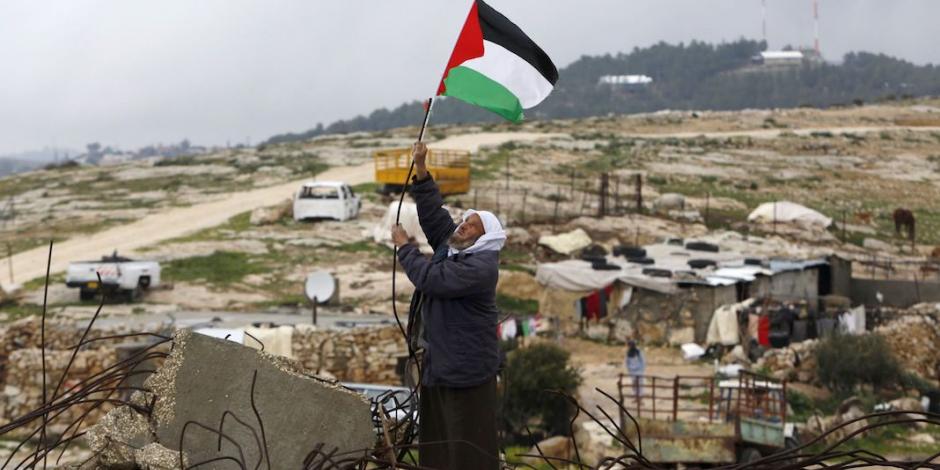 Un hombre cuelga una bandera palestina en el sur de Cisjordania, en enero.