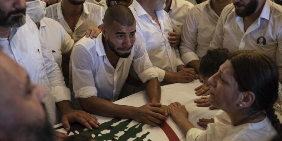 Parientes y amigos del bombero Ralph Malahi, de 23 años, muerto en la explosión del 4 de agosto que arrasó el puerto de Beirut, asisten a su funeral, sábado 15 de agosto de 2020.