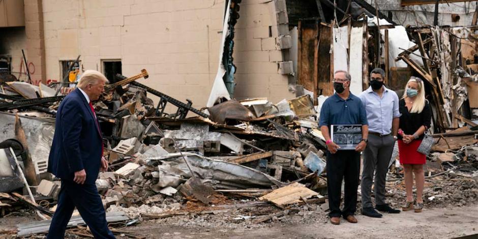 El republicano (izq.) visita, ayer, una antigua tienda destruida en las protestas de Wisconsin.