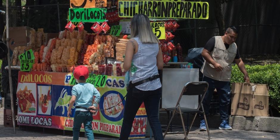 Un pequeño y su madre se acercan a un puesto de frituras, en la Ciudad de México, a principios de agosto.