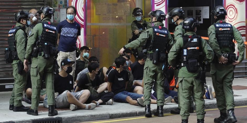Policías resguardan a algunos de los manifestantes detenidos, ayer.
