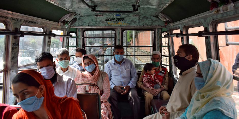 Pasajeros con mascarilla viajan a bordo de un autobús en Srinagar, ayer.