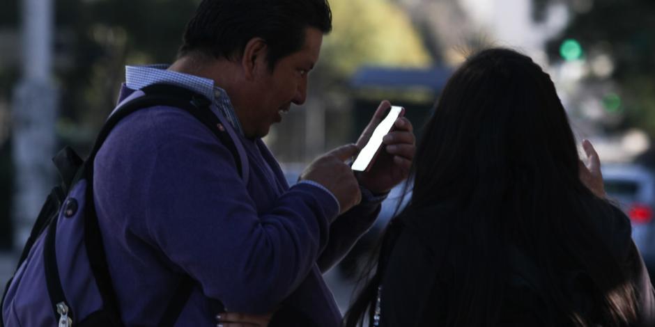 En la imagen de archivo, un hombre revisa su celular junto a su pareja, en calles del Centro Histórico.