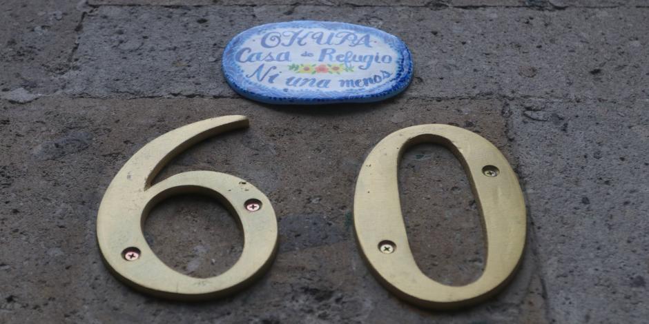 Integrantes de colectivas feministas colocaron una placa encima del número 60 con el lema "Okupa Casa de Refugio Ni una Menos".