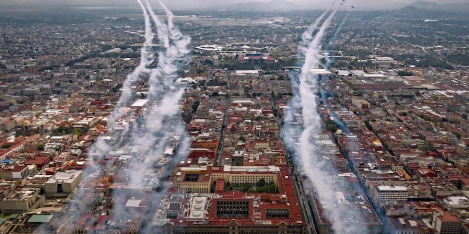 Aviones de la Fuerza Aérea sobrevuelan las calles de la capital, lanzando humo de colores, ayer.