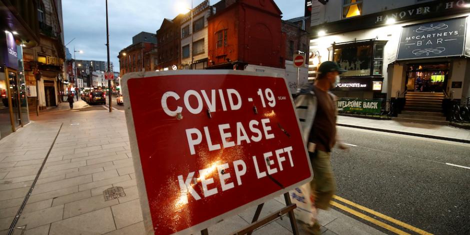 Un hombre pasa junto a una señalización en Liverpool, Reino Unido, ayer.