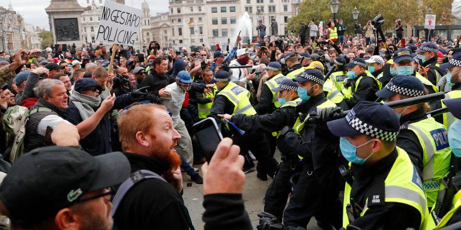 Agentes de la policía metropolitana de Londres chocan con manifestantes durante protesta contra las restricciones por el COVID-19