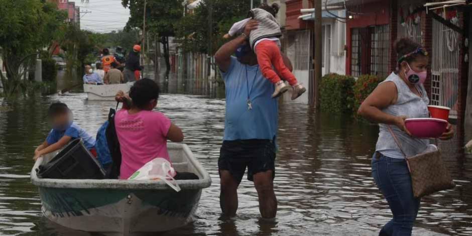 Familias afectadas en Nacajuca recuperan algunas pertenencias para abandonar sus casas tras las inundaciones.