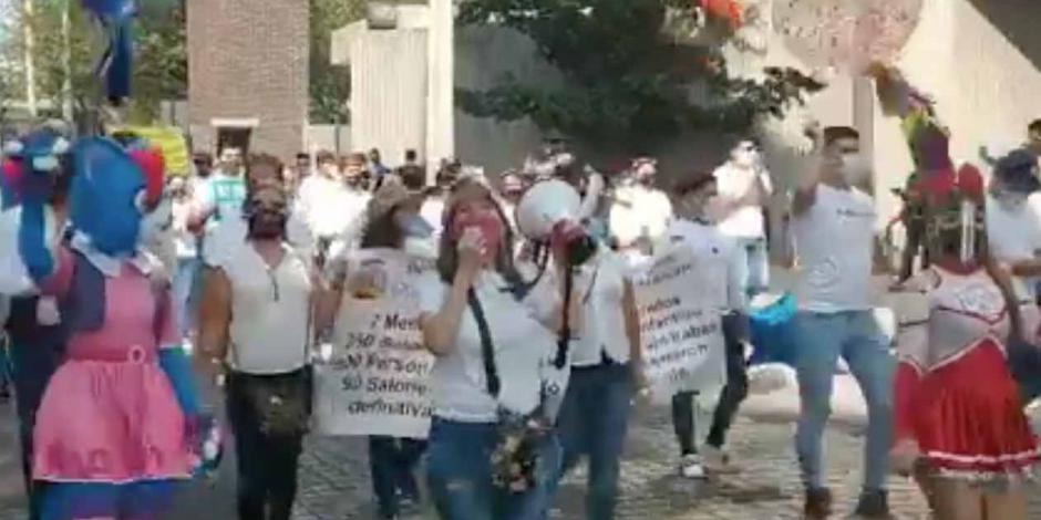 Trabajadores de salones de fiestas infantiles marchan hacia la Secretaría de Salud estatal.