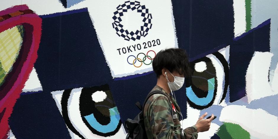 Un hombre camina frente a un anuncio de los Juegos Olímpicos de Tokio 2020 en la capital de Japón.