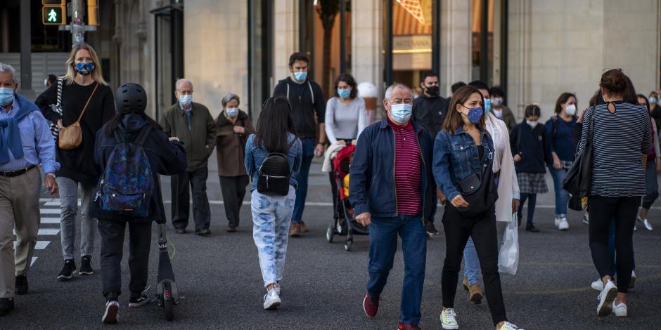 Personas que llevan cubrebocas para prevenir la propagación del coronavirus cruzan una calle en Barcelona, España, 13 de octubre de 2020.