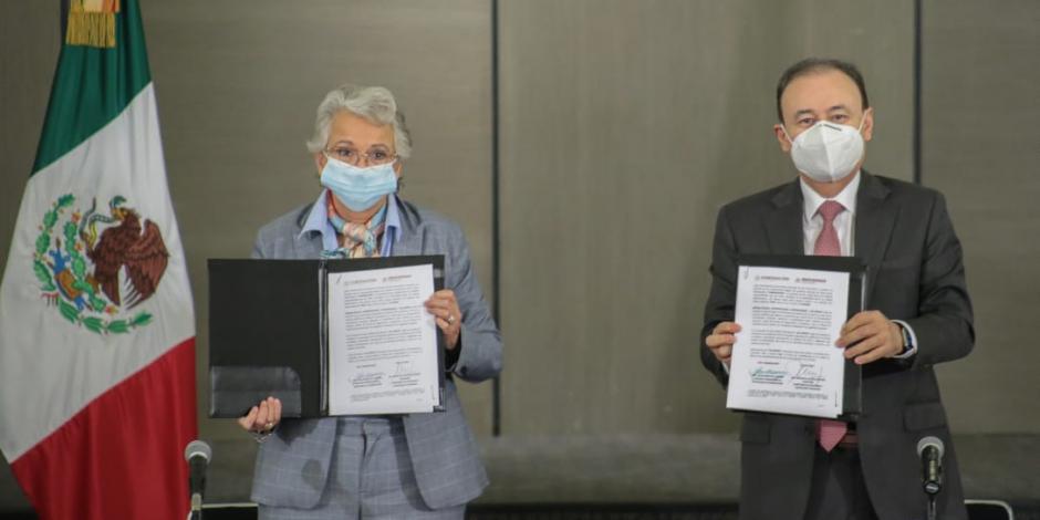 Olga Sánchez Cordero y Alfonso Durazo muestran el documento recién firmado.