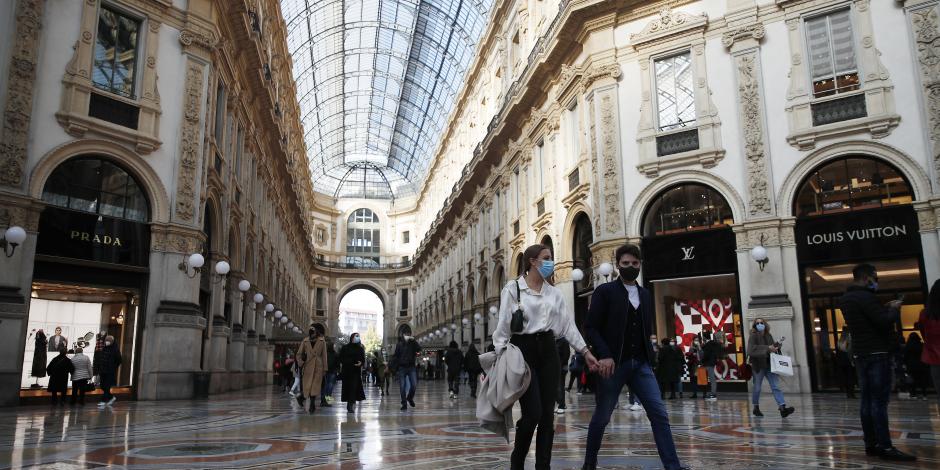 Unas personas usando cubrebocas caminan por el centro de Milán, Italia.