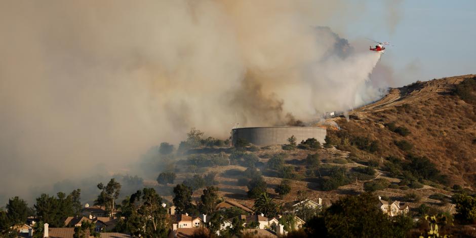 Un helicóptero arroja agua sobre las llamas de un incendio en Silverado, cerca de Lake Forest, California, este 27 de octubre.