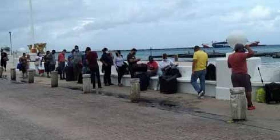 Turistas hacen fila en espera de poder tomar una embarcación en Cozumel.