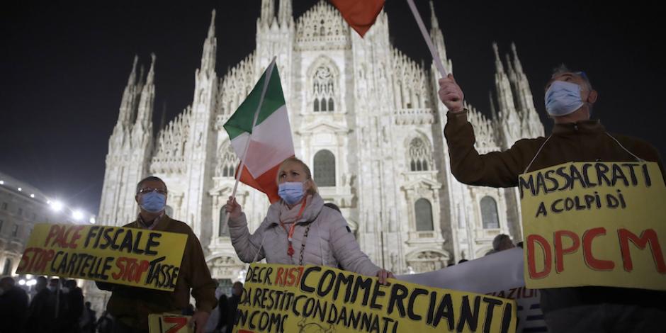 Manifestantes claman contra las restricciones del gobierno, frente a la catedral gótica de Milán, ayer.