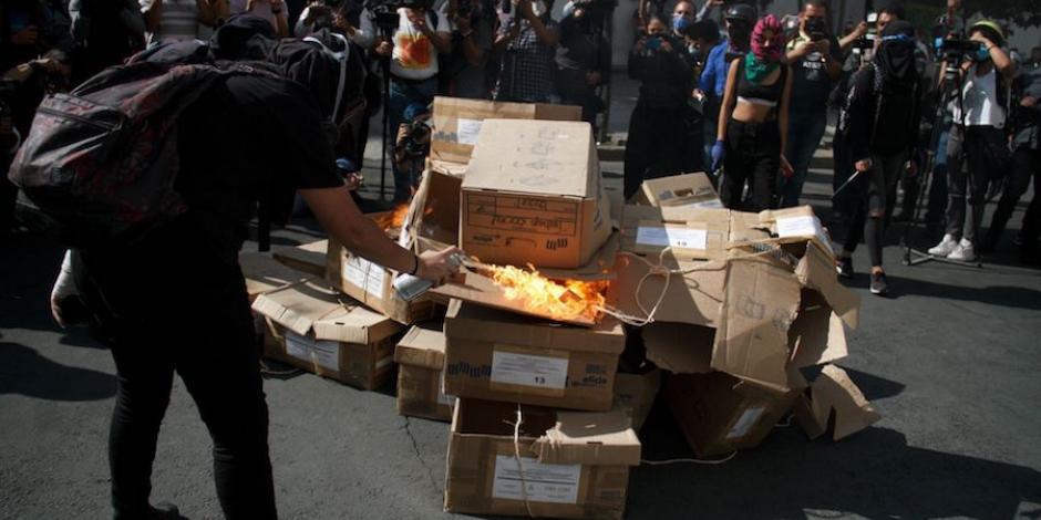 Mujer quema cajas afuera de la Fiscalía capitalina, ayer.