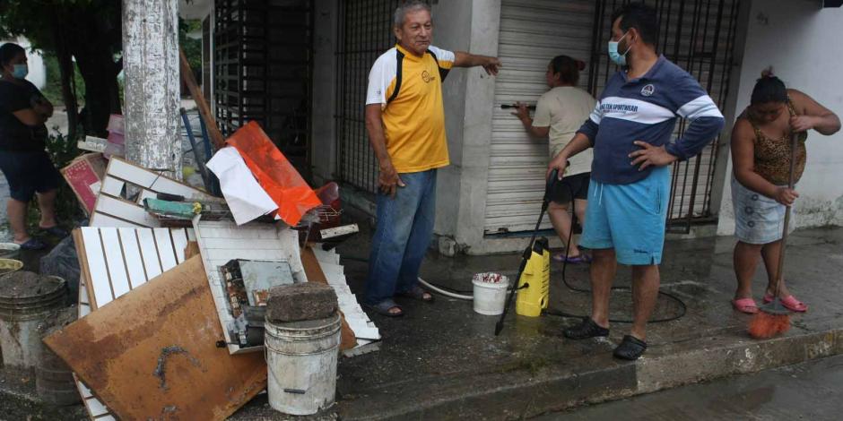 Damnificados realizan labores de limpieza en calles por las inundaciones.