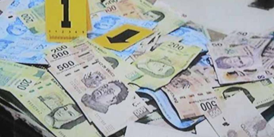 Autoridades presentan billetes falsos decomisados.