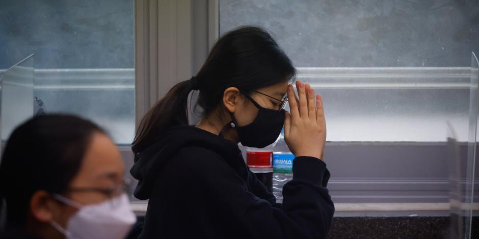 Una estudiante reza antes de los exámenes anuales de ingreso a la universidad en medio de la pandemia de la enfermedad del coronavirus en un salón de exámenes en Seúl, Corea del Sur.