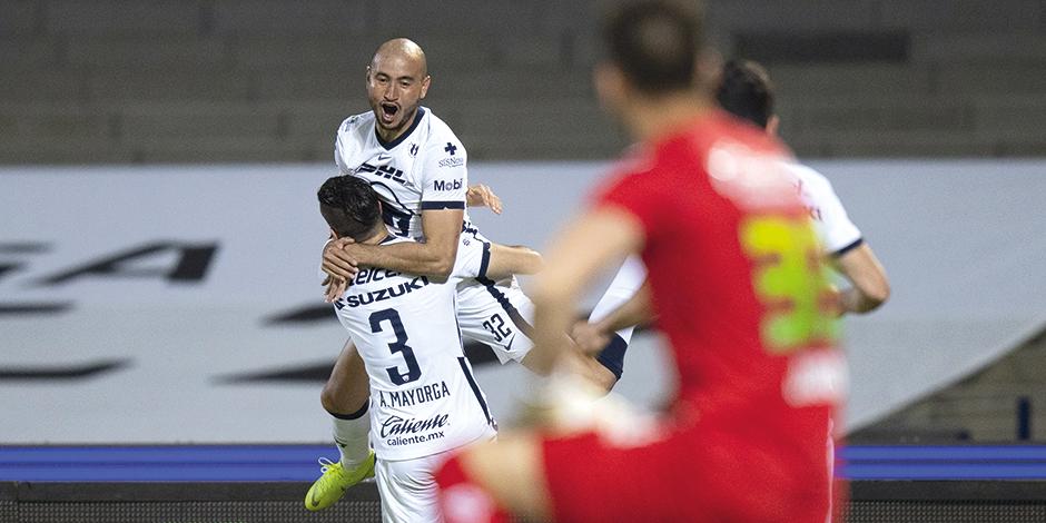 Jugadores de Pumas celebran un gol ante la mirada de Jurado, ayer, en CU.