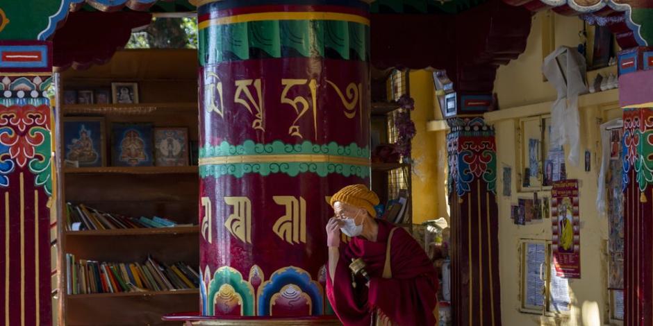 Un monje budista tibetano se protege del coronavirus con un cubrebocas.