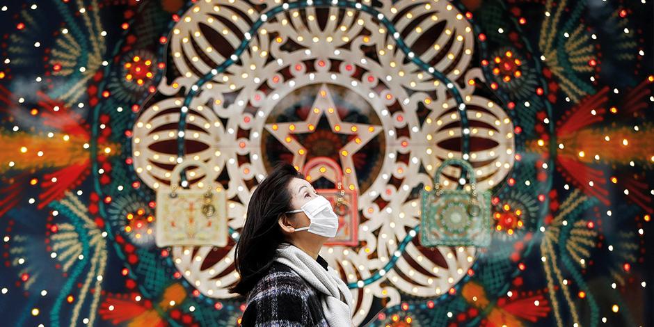 Una mujer camina frente a un escaparate con luces de colores en Tokio, Japón, el sábado.