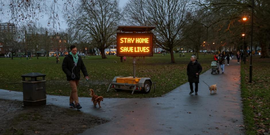 Personas pasean a sus perros en un parque de Fulham, Londres, ayer.