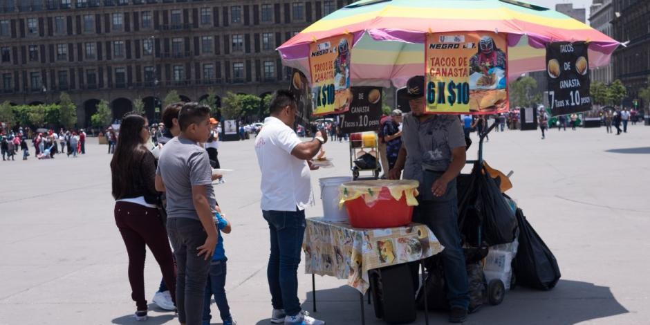 Un comerciante vende tacos de canasta en la plancha del Zócalo