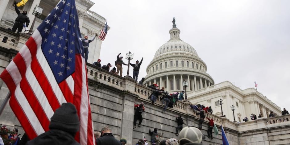 Partidarios de Donald Trump trepan las paredes del Congreso, en protesta por el triunfo de Joe Biden, ayer.
