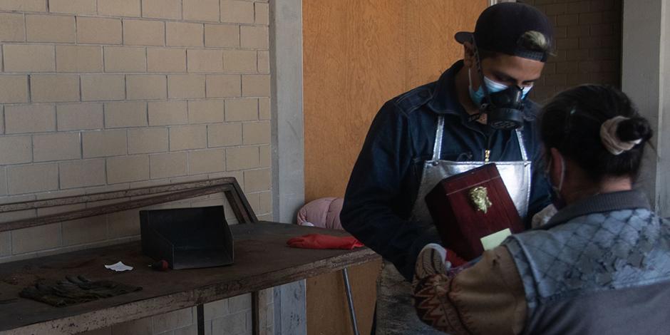 Un trabajador entrega las cenizas de una muerte a causa de Covid-19 a un familiar en el Crematorio municipal Nezahualcóyotl.