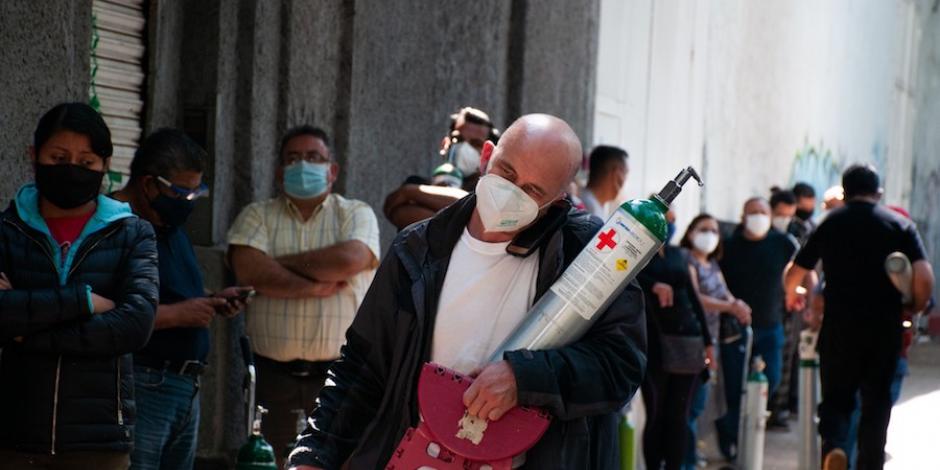 Un hombre carga un tanque de oxígeno que busca rellenar, ayer, en Miguel Hidalgo.