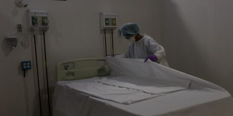 Enfermera de área covid prepara una cama de hospitalización.