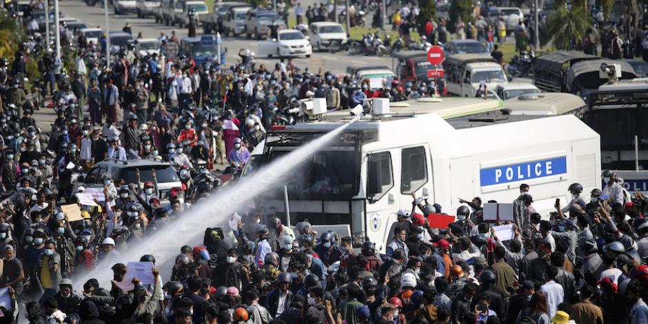 Militares intentan dispersar a chorros de agua a manifestantes, ayer.
