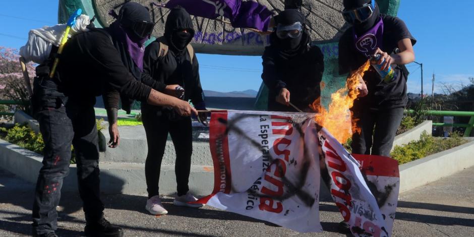 Encapuchadas queman un banderín de Morena, ayer, en Chilpancingo.