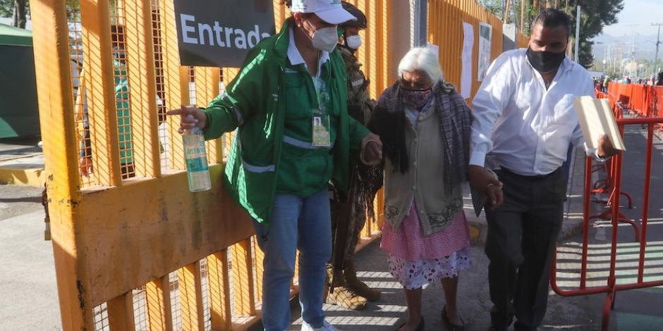 Una brigadista recibe en la entrada del centro de vacunación a una mujer de 80 años, en Xochimilco.