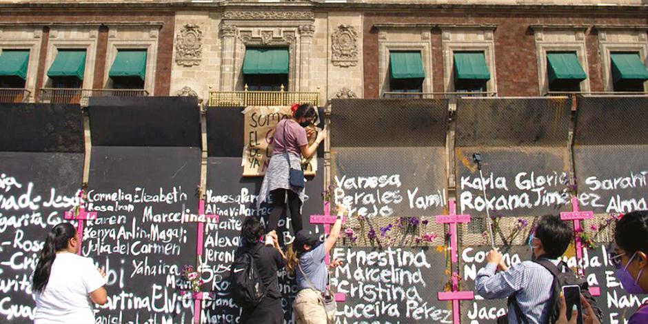 Mujeres colocaron  ayer flores, cruces rosas, moños morados, veladoras y nombres de víctimas de feminicidio en las vallas colocadas alrededor de Palacio Nacional.