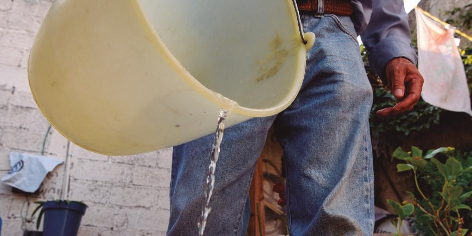 Un hombre raciona agua en un boto, en Iztapalapa.