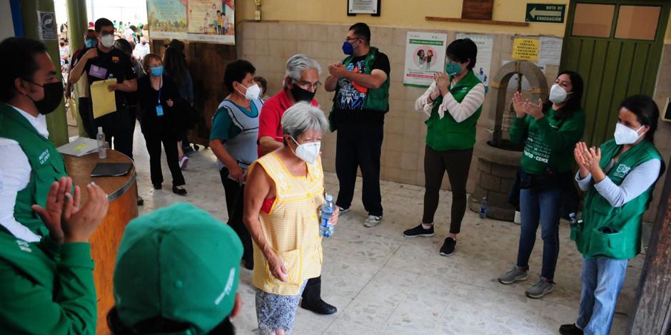 Adultos mayores son aplaudidos a su salida tras vacunarse contra el COVID-19 en la alcaldía Venustiano Carranza.