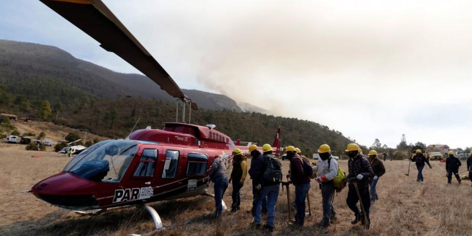 Brigadistas de protección civil trabajan para controlar el incendio forestal en Nuevo León.