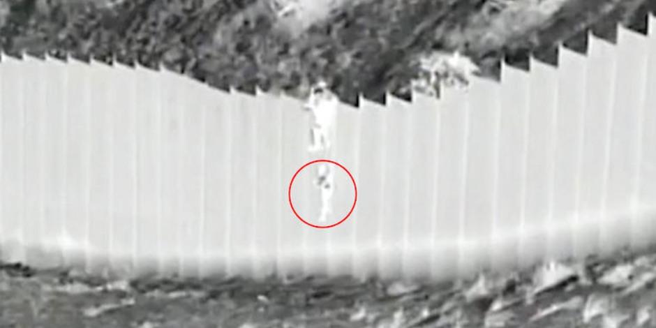 En la grabación se observa el momento en que un sujeto trepado sobre el muro fronterizo deja caer a dos niñas.