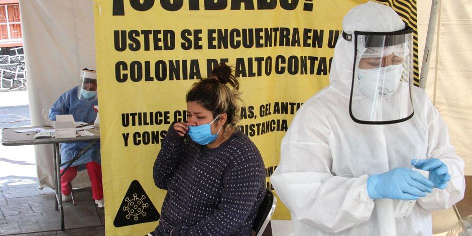 Una mujer se limpia las lágrimas tras toma de muestra nasal para la detección de COVID-19.